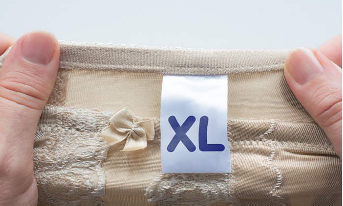 hands stretching out shapewear with a tag that says XL